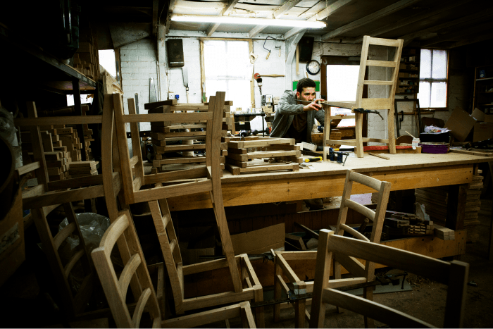 a-man-working-in-a-furniture-makers-workshop-assem-SVBH9EH 2